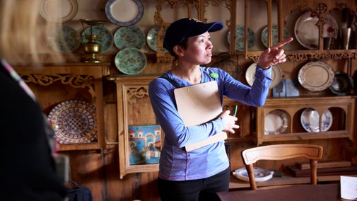 Visitors being shown some items by member of staff on a house tour